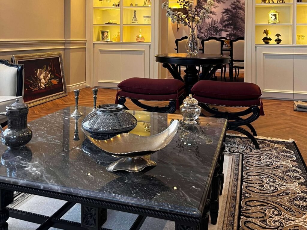 Premium black marble coffee table paired with elegant tufted ottomans in a classic salon.